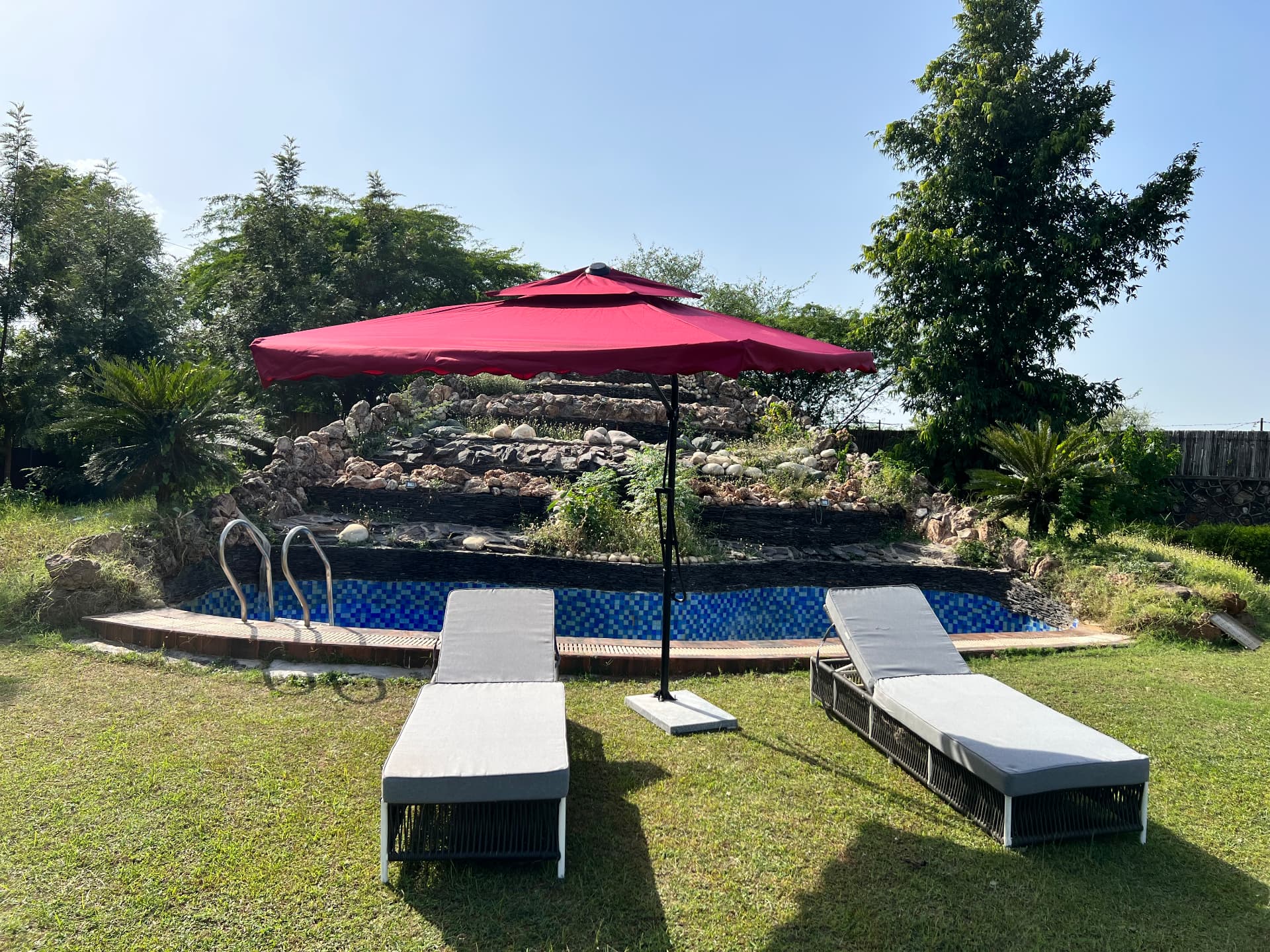 Poolside with sun loungers and the rock waterfall