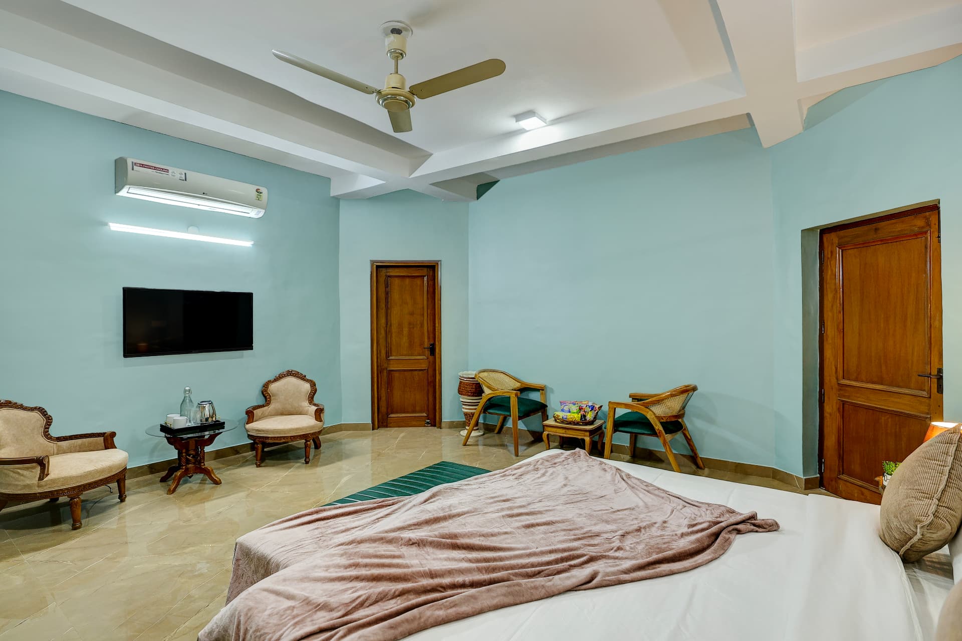 Mint bedroom seating area with TV, air conditioning and tea service